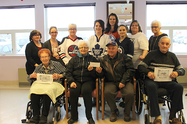 Participating in the donation presentation at Dauphin Personal Care Home are, from front row (l to r) Helen Safronetz, Iris and Ernie Trotz and Jim Park.  Back row (l to r) are Wanda Boyd, Patient Services Manager, Nicole ViIllers, Clinical Resource Nurse, Sally Verhaeghe, Activities Director, Crystal Rudkavich, Activity worker, Crystal Abraham, Care Team Manager, Shyla Baumung, Activity worker, Sharon Derhousoff, Social Worker and Marilyn Park, Resident Family member.